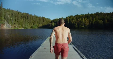 Man run on dock to jump in cold mountain lake Stock-Footage 132791639