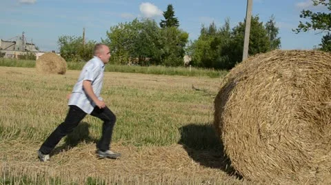 Man run strike crash fall down round straw bale Stock Footage 22417452