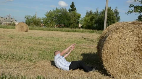 Man run strike hit fall down round straw bale agriculture field Stock Footage 18015059