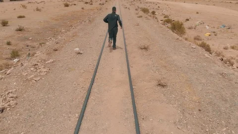 A man is run of Train tracks running across the  Uyuni Salt Flat, Bolivia Stock Footage 125483910