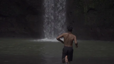 Man Runing Towards Bali Waterfall Stock Footage 106152018