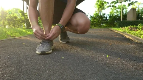 Man runner getting ready tying running shoes before running Video stock 113990229
