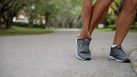 Man runner has ankle sprain. Sprained ankle after running. Arthritis and tendon Stock Footage 311344032