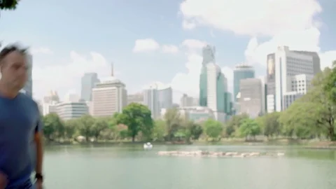 Man runner jogging in park. Fit male sport fitness running training. Having a Video stock 74314886