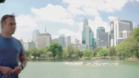 Man runner jogging in park. Fit male sport fitness running training. Listen Stock Footage 74314914