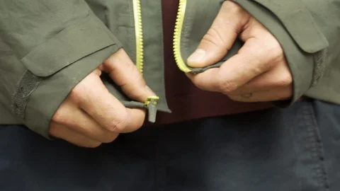 Man runner pulling zip on sport jacket Otago Video stock 112963194