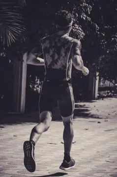 A man runner on the street doing exercises Stock Photos