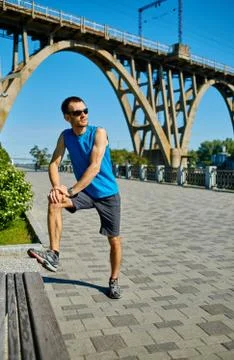 Man runner warming up before jogging Stock Photos