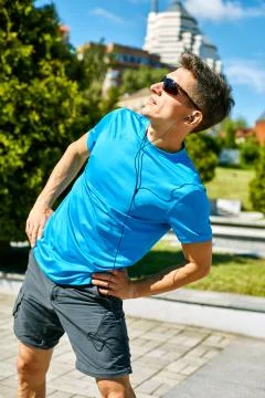 Man runner warming up before jogging Stock Photos
