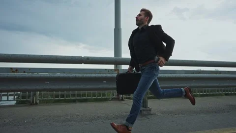 Man running across bridge during overcast weather in the late afternoon Stock Footage 285931147