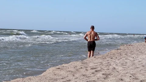 A man is running along the beach. Waves, sand, beautiful horizon Stock Footage 94422811