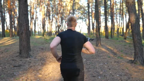 Man running along forest path at sunny day. Male sportsman working out Stock Footage 300163024