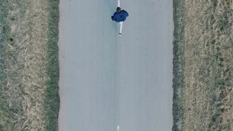 A man is running along the road. View from above. Aerial Stock Footage 73463724