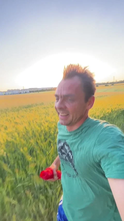 Man running along rural path at sunset with golden backlight and lens flare Видео 344584081