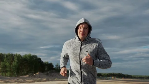 The man is running along a sandy beach front view Stock Footage 129515189