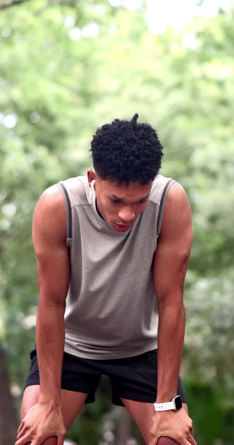 Man, running and break in park with smart watch, check heart rate and earphones Stock Footage 340749878