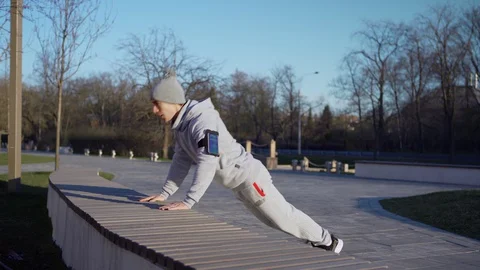 Man running and doing pushups in park Stock Footage 129557857