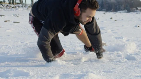Man running and falling in the snow - Slowmotion 100fps Stock Footage 87840589