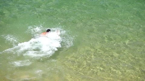 Man running and going into beautiful turquoise beach water and swimming. Stock Footage 149679842