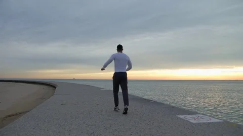 Man is running and warming up on the ebankment. Athlete training outdoors. Stock-Footage 82644554