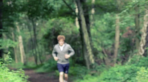 Man running around a corner in the forest downhill Stock Footage 41097798