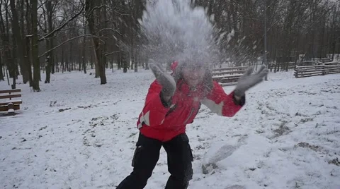Man is Running Around Sits Down And Picks Up Snow Throws the Snow toward a Stock Footage 59079857