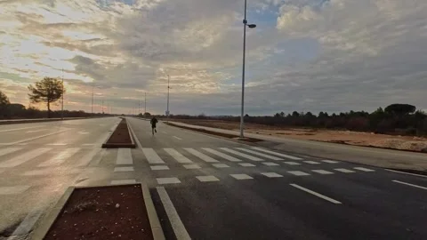 Man running away on an empty road crosswalk at sunrise. Stock Footage 335306936