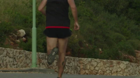 Man running away outside away from camera 動画素材 130865448