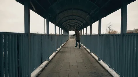 Man running away through the footbridge Stock Footage 78381729