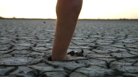 Man running barefoot on bottom of dried lake with mud Stock Footage 196822228