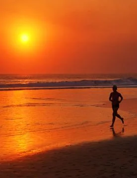 Man Running on the Beach During Sunset Foto stock
