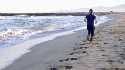 Man running on the beach Stock Footage 73928462
