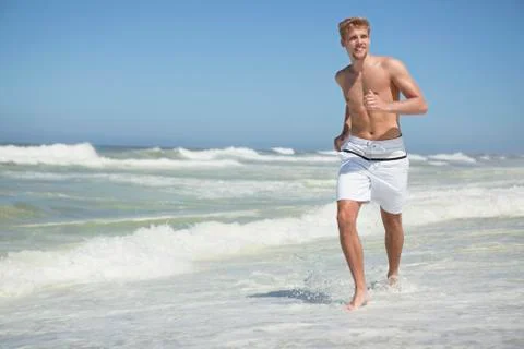 Man running on the beach Stock Photos