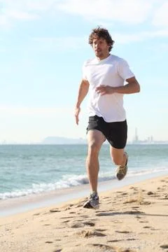 Man running in the beach Stock Photos
