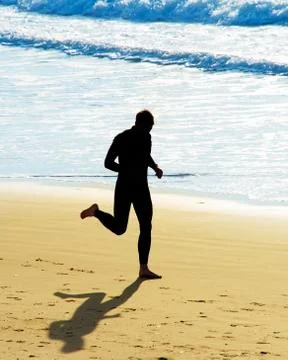 Man running on a beach Stock Photos