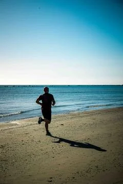 Man running on the beach Stock Photos