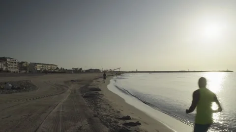 Man running on the beach at sunrise along the sea shoreline Stock Footage 342445965
