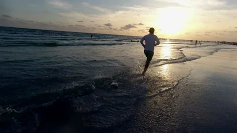 Man Running on Beach Sunset Aerial Follow Shot Fitness Video stock 340319402