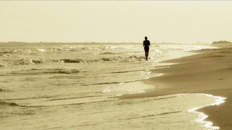 Man running on the beach at sunset Stock Footage 34462754