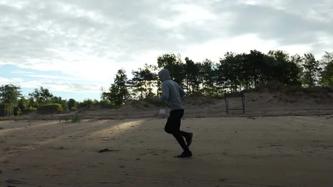 Man running on the beach at sunset Stock Footage 129515165
