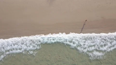Man running on beach. Top view aerial drone footage, sea waves on beach Stock Footage 166430018