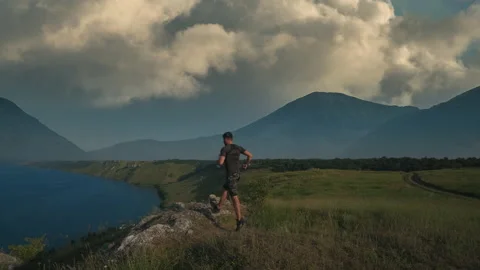 The man running on a beautiful mountain background. slow motion Stock Footage 203497171