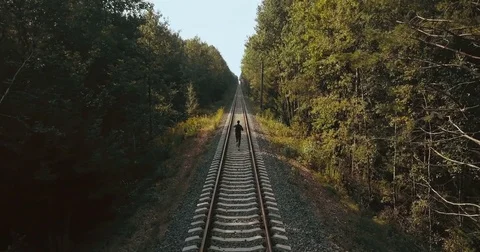 Man running between the rail lines. Drone back view. Athlete rushing to new Stock Footage 83254800