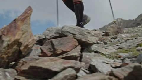 Man running in a big mountains with pole sticks. Close up of legs and running Видео 203823776