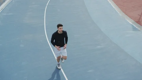 Man running on blue track Stock Footage 100029099