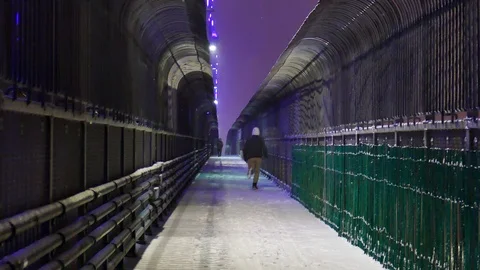 Man running on a bridge during snowfall Stock Footage 125548372