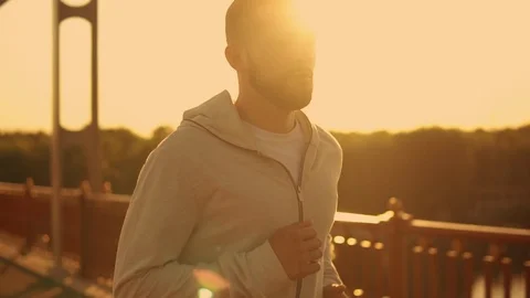 Man running on the bridge at sunset Stock Footage 92023374
