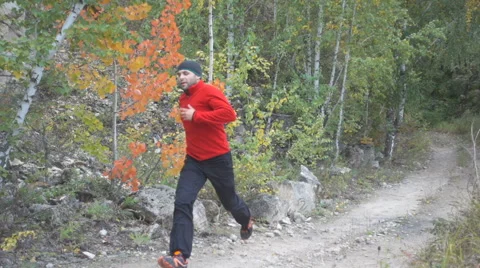 Man running cross country in autumn mountain. Jogging motivation in green par Stock Footage