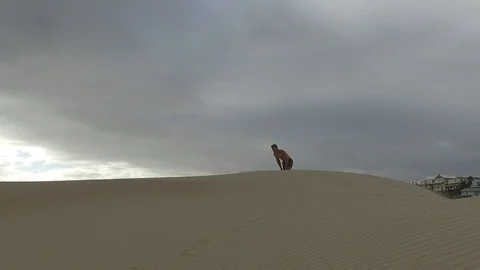 Man running on dunes slow motion sunset Vidéo 104312617