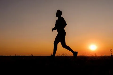 Man running during sunset Stock Photos